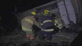 Un grupo de bomberos trabaja en el rescate de supervivientes del autobús que cayó por un barranco en Nayarit.