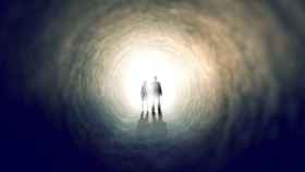 Dos personas caminan hacia la luz del final del túnel.