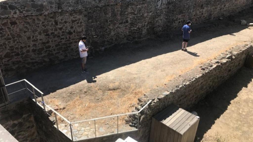 Varios turistas, testando la herramienta de la Universidad de Extremadura en unos restos arqueológicos.