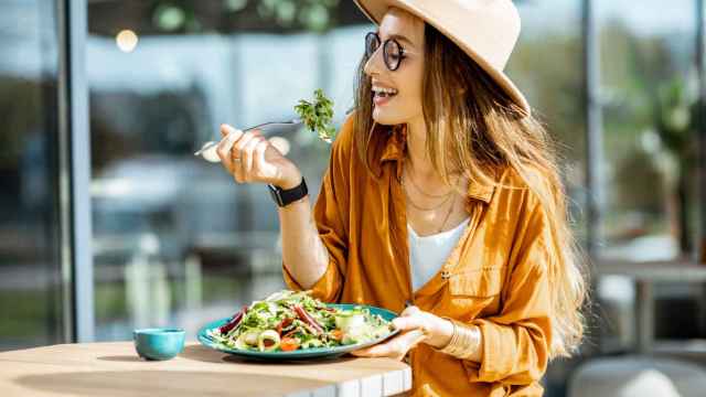 Mujer comiendo ensalada en una terraza