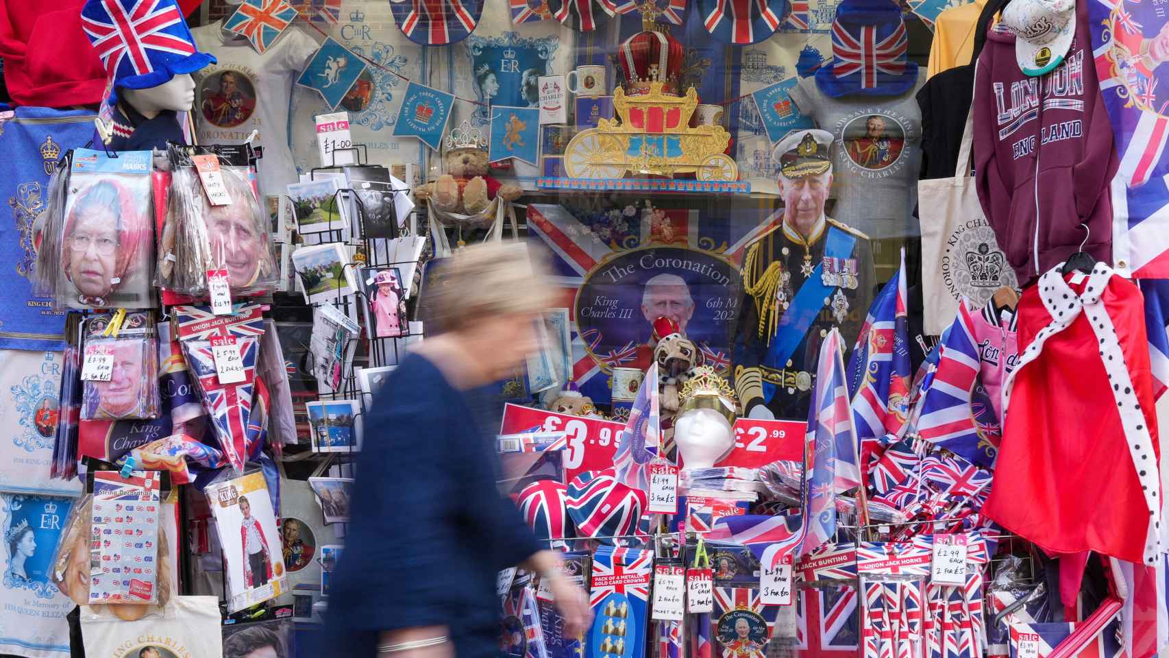 Una mujer pasa por delante de un establecimiento con souvenirs de Carlos III de Inglaterra.