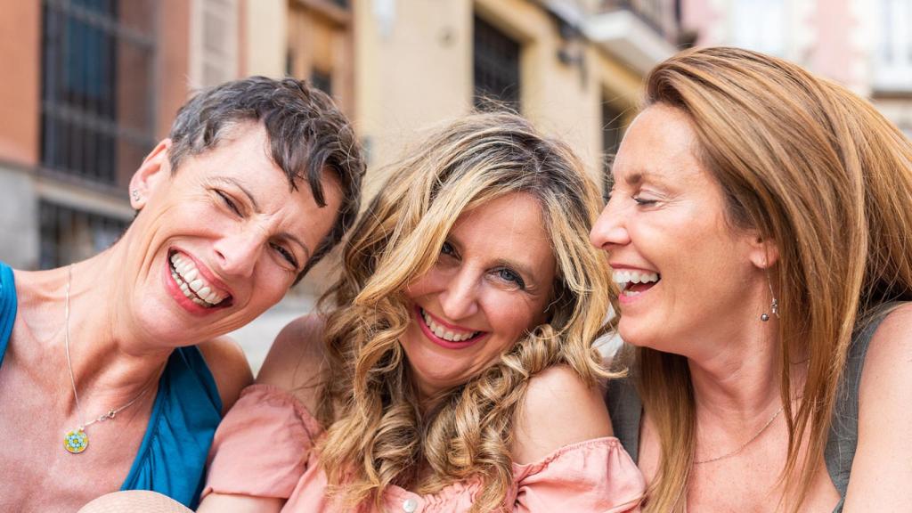Tres amigas riendo juntas