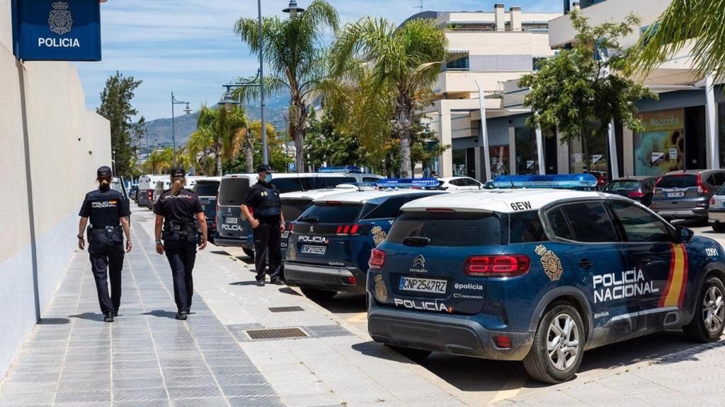 Agentes de la Policía Nacional junto a vehículos oficiales.