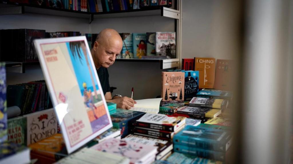 Agustín Rivera firma ejemplares de su libro.