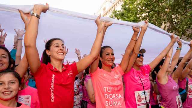 Carolina Marín y Begoña Villacís participan en el despliegue de un lazo rosa gigante en la Carrera de la Mujer de Madrid, este domingo.