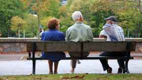 Tres personas mayores sentadas en un banco.