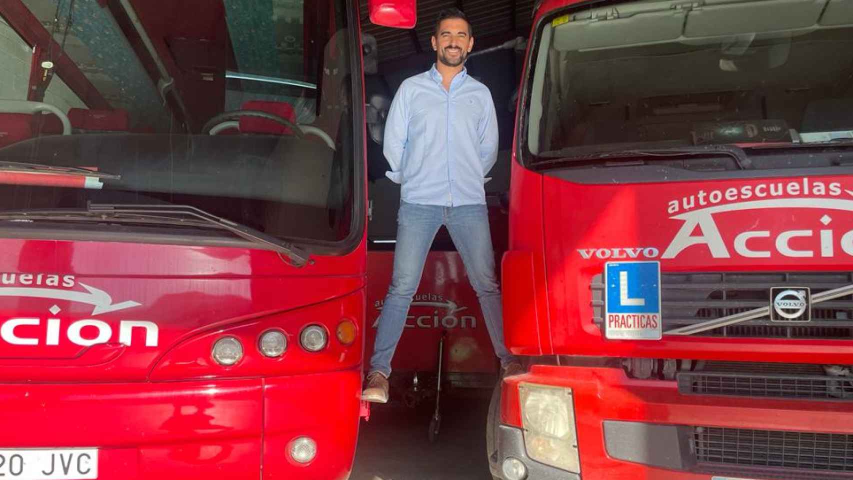Andrés Caballero, de la Autoescuela 'Acción' en Puente Genil, con un camión y un autobús de prácticas.