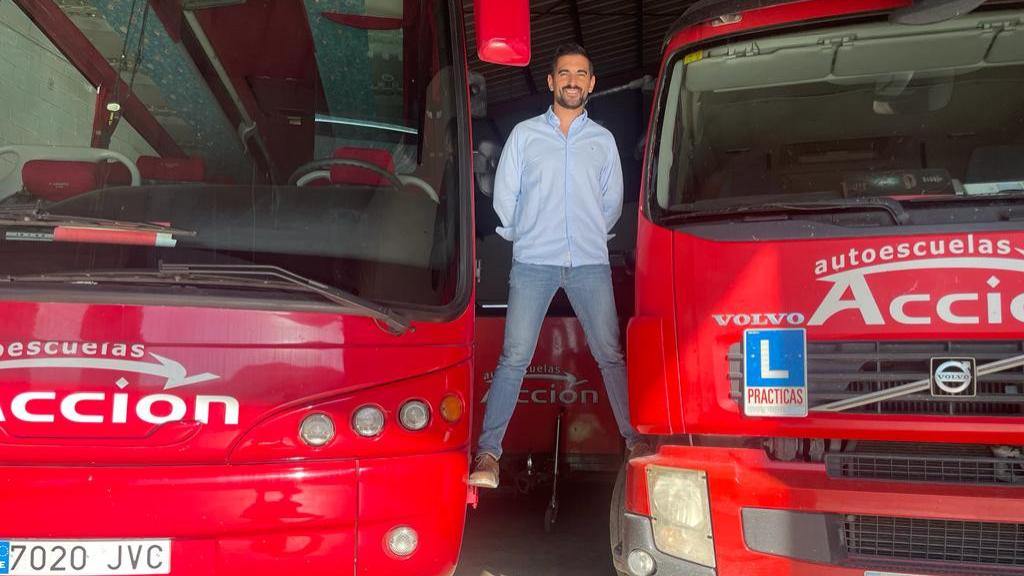 Andrés Caballero, de la Autoescuela 'Acción' en Puente Genil, con un camión y un autobús de prácticas.