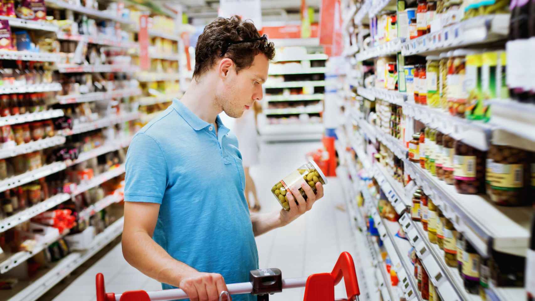 Un hombre eligiendo un producto en el supermercado.