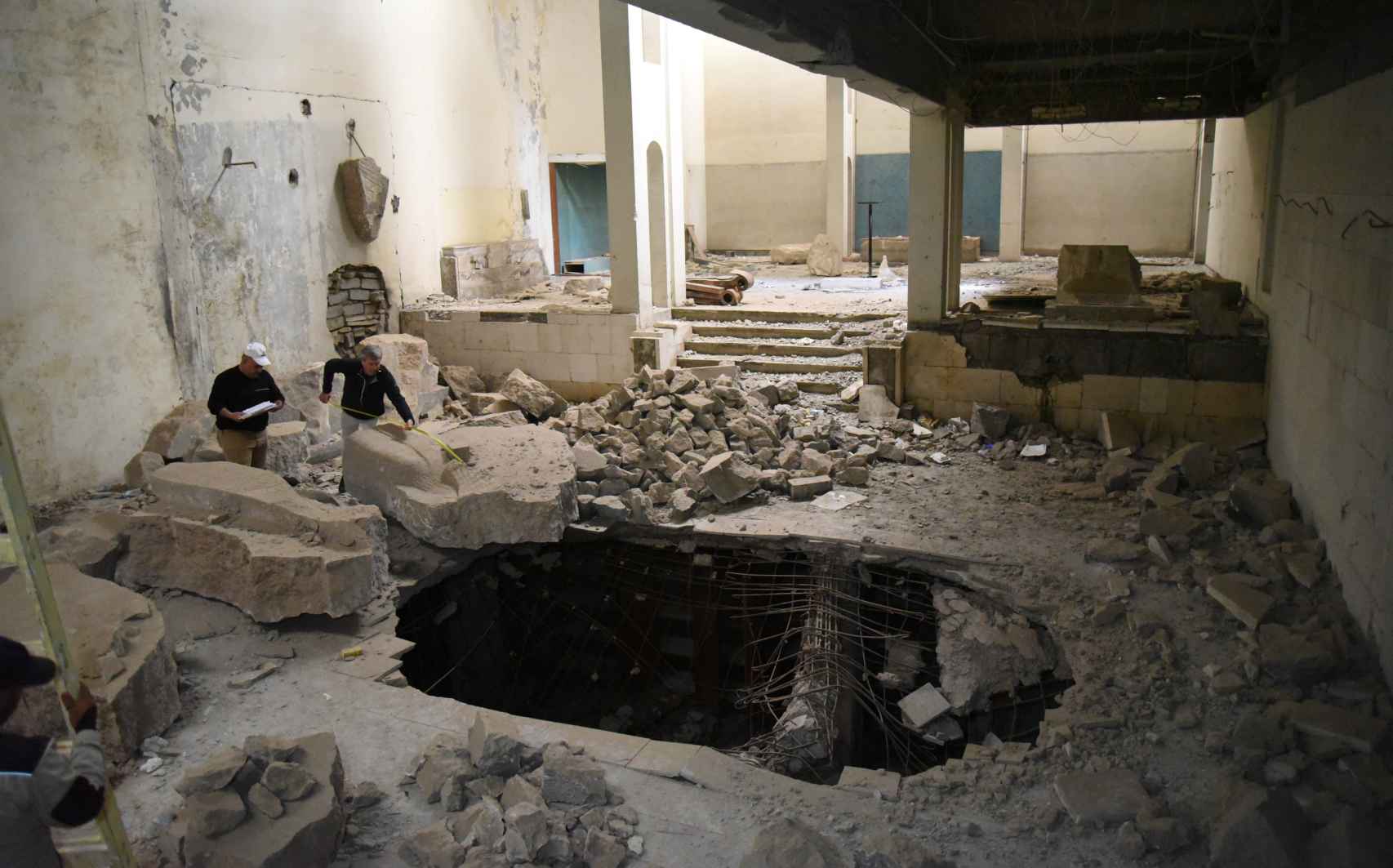 Trabajadores del museo inspeccionan los destrozos provocados por una bomba en la galería de Asiria.