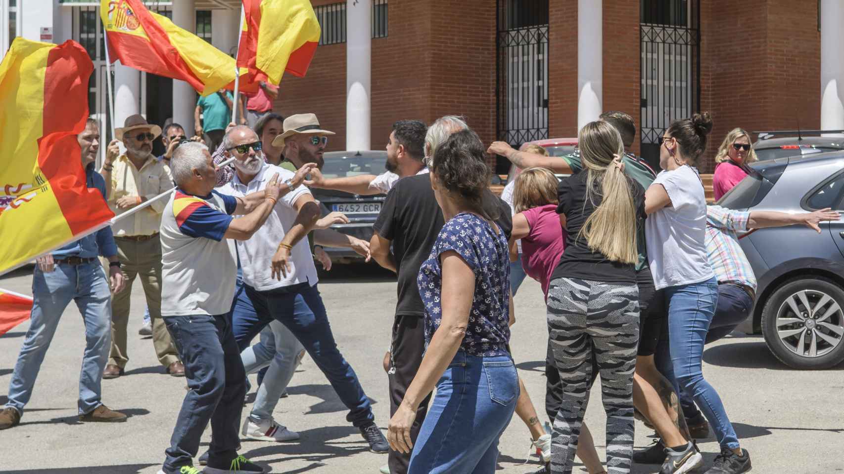 Militantes de Vox (i) y vecinos de Marinaleda se enfrentan junto al Ayuntamiento de la localidad.