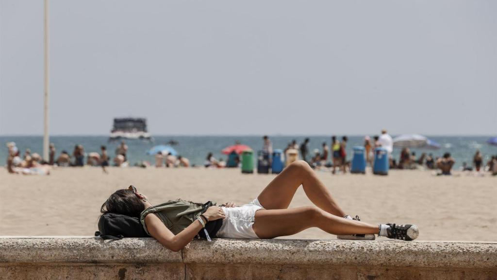 Una persona toma el sol en una playa valenciana, en imagen de archivo.