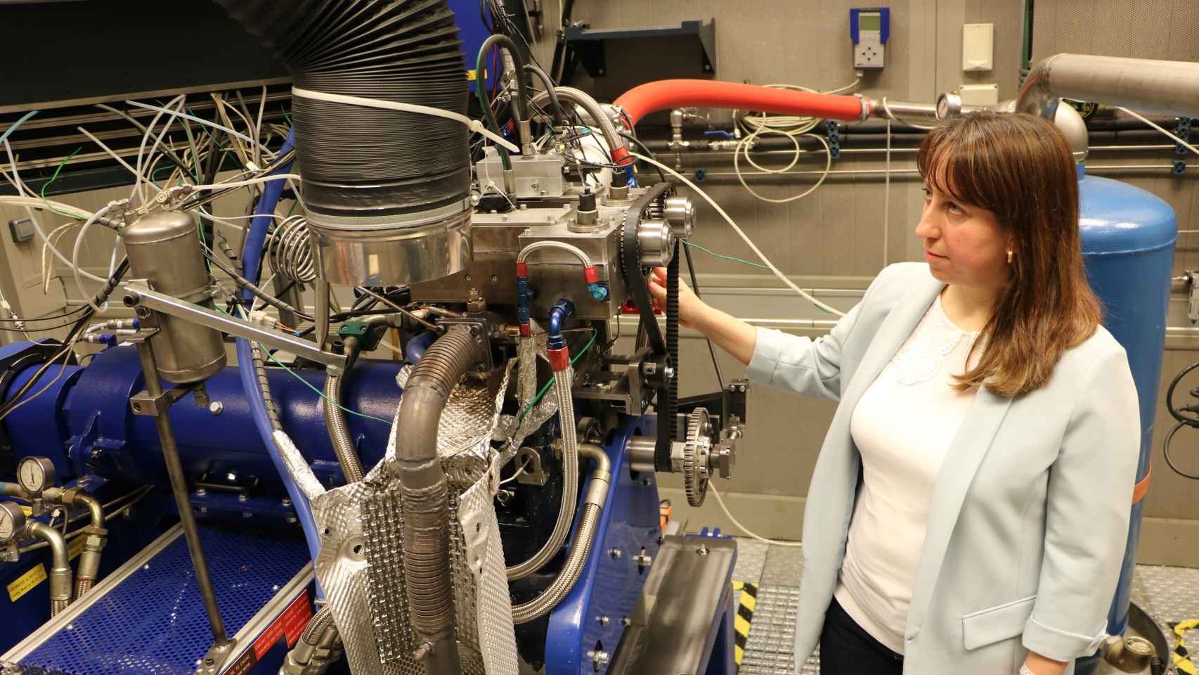 Dolores Cárdenas junto a un prototipo de un motor para saber cómo funcionan los diferentes combustibles.