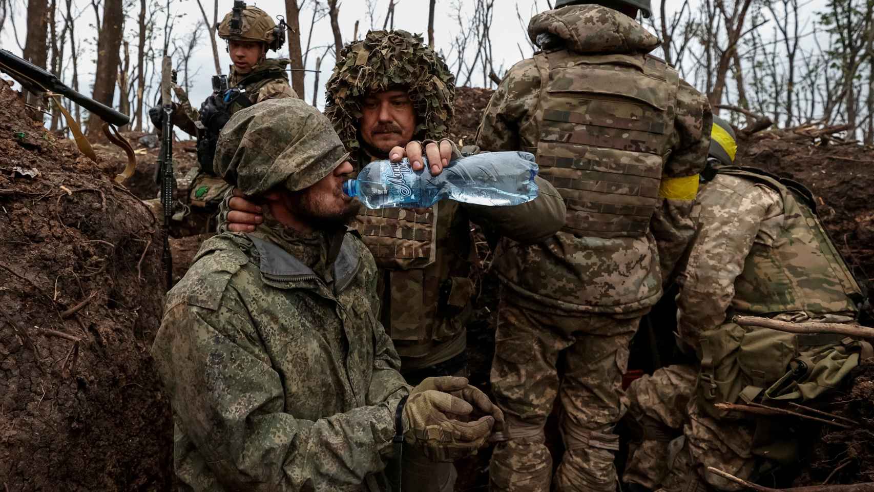 Un soldado ucraniano le da agua a un soldado del ejército ruso capturado cerca de la ciudad de Bakhmut, en la línea del frente.