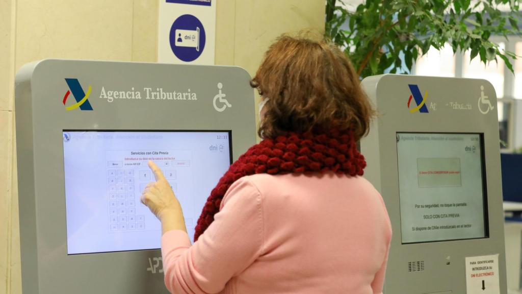 Una jubilada pide turno en una oficina de la Agencia Tributaria.