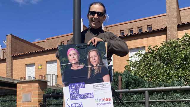El candidato de Unidas Podemos en Yebes (Guadalajara) con uno de los carteles electorales.