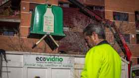 Imagen de archivo de operarios de gestión de residuos vaciando los contenedores verdes donde se deposita el vidrio.
