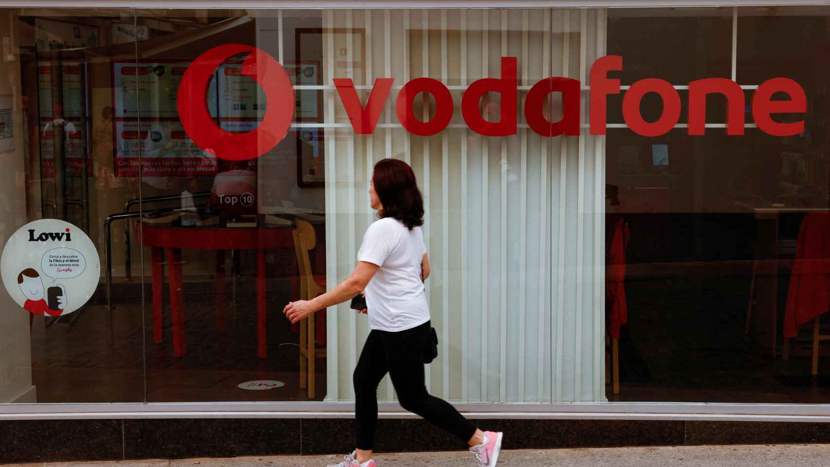 Una mujer pasa por delante de una tienda de Vodafone en Ronda (Málaga).