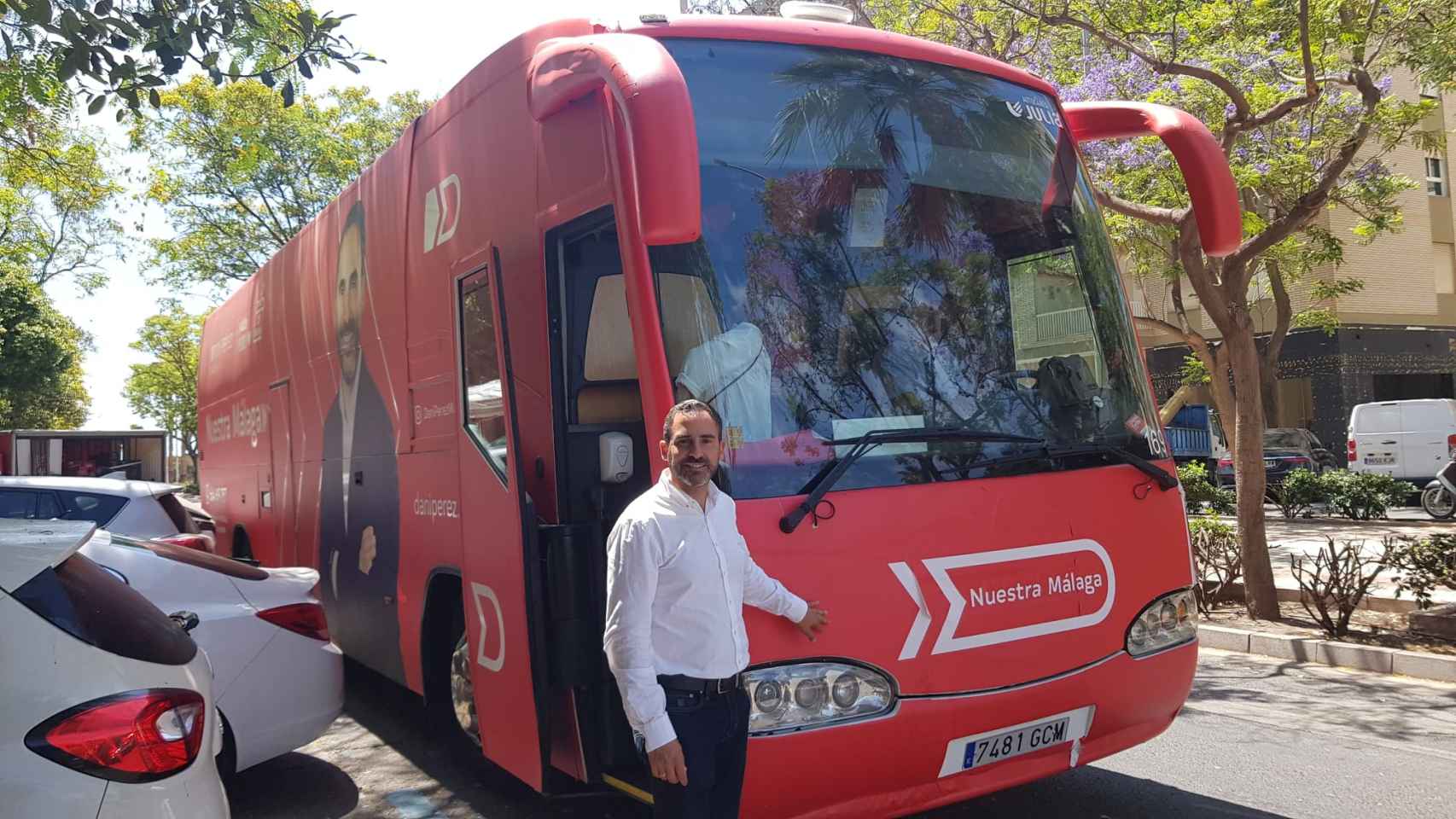 El candidato socialista Daniel Pérez posa junto a su autobús.