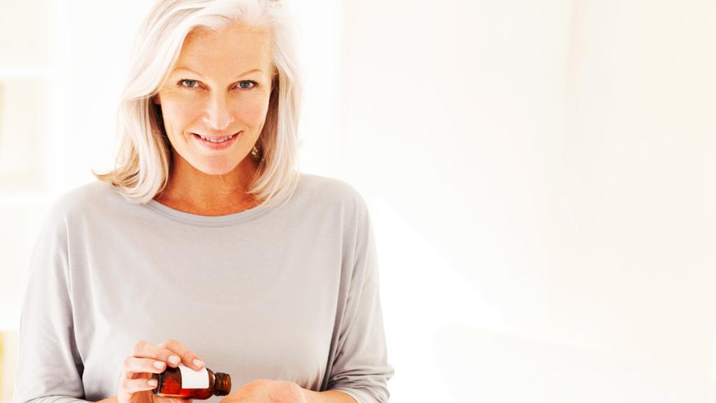 Una mujer tomando suplementos nutricionales.