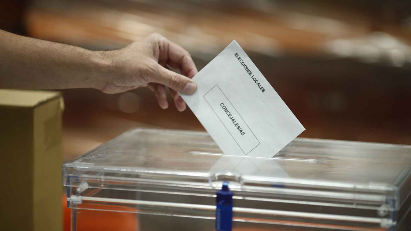 Un hombre deposita su voto en unas elecciones municipales en España.