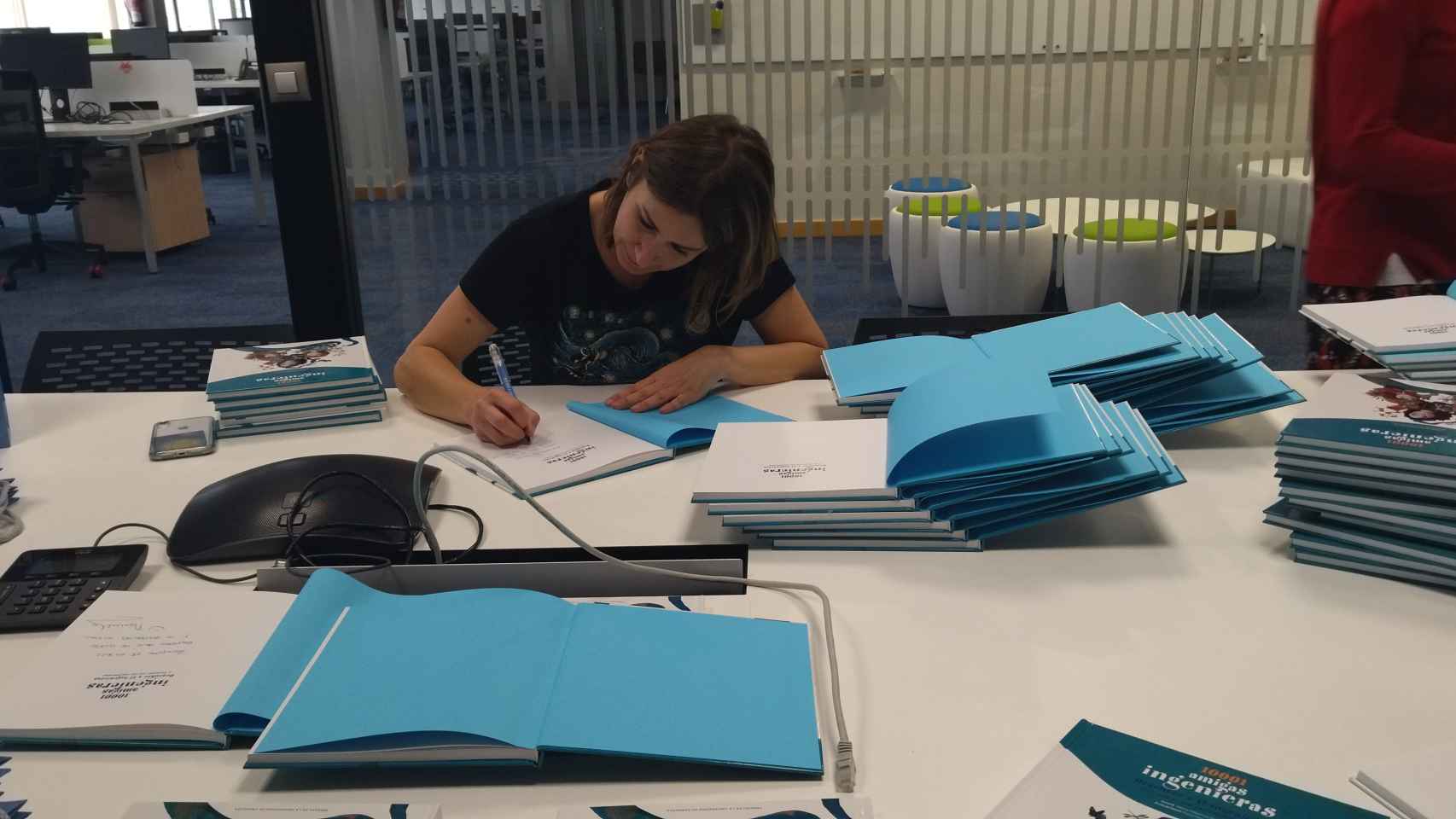 Manuela Delgado firmando ejemplares del libro '10001 amigas ingenieras'.