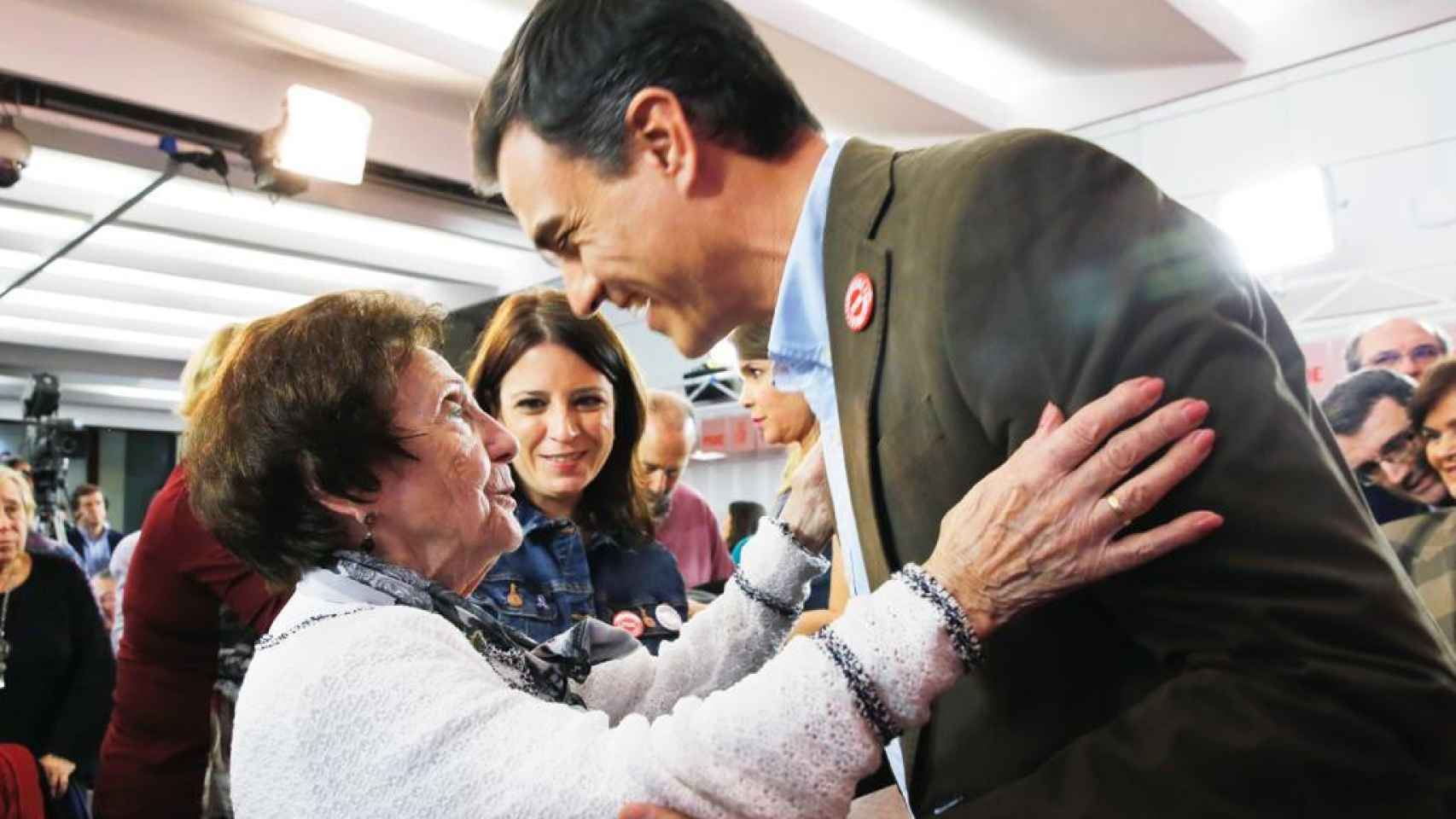 Pedro Sánchez y Maricuela se saludan en un acto del PSOE, con Adriana Lastra entre ambos.
