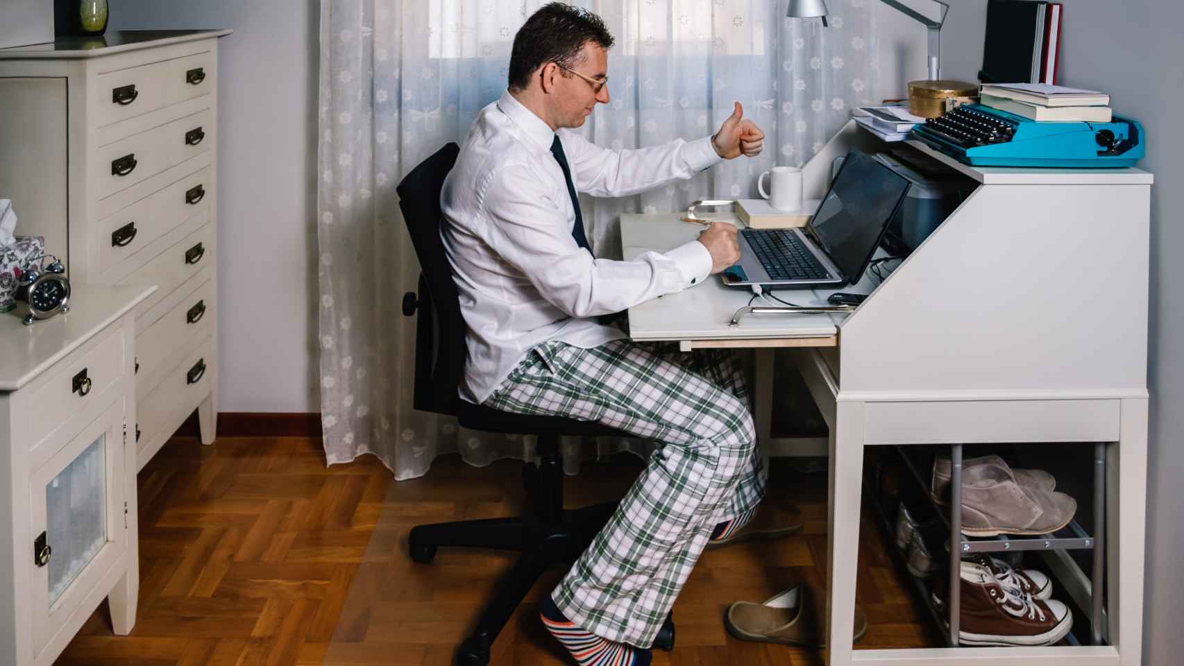 Imagen de archivo de una persona trabajando desde casa con el pijama.