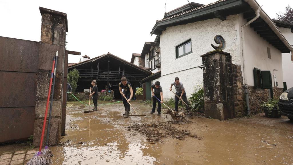 Un grupo de personas limpia los daños causados por las inundaciones en Bera (Navarra).