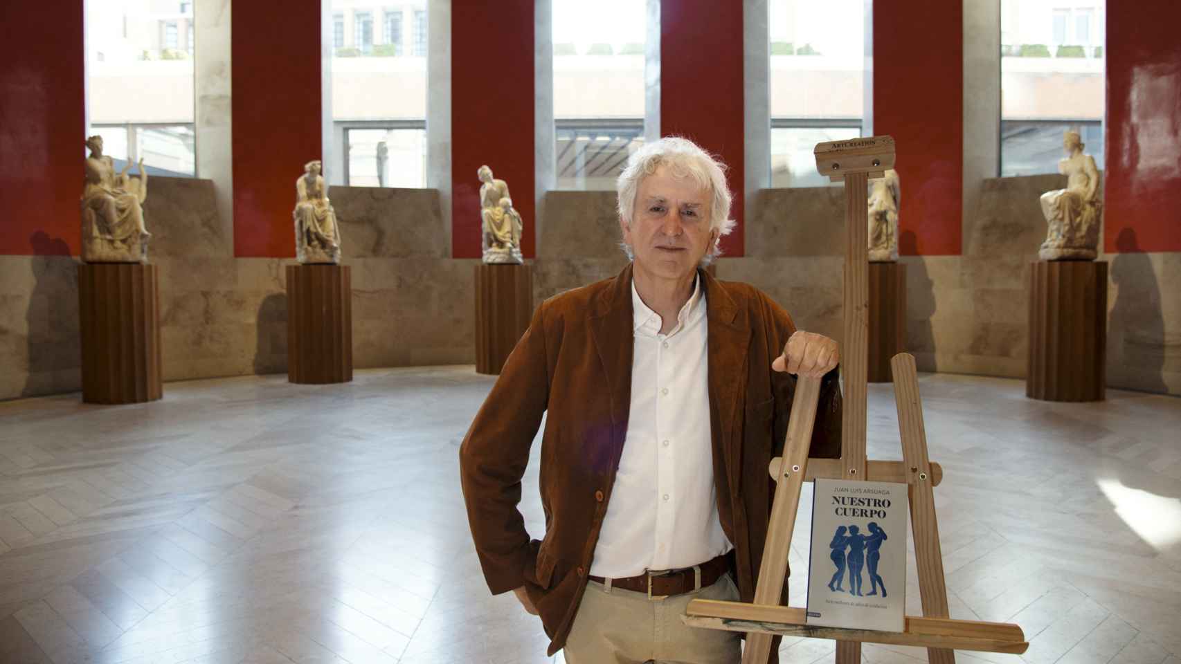 Juan Luis Arsuaga posa con su libro en la Sala de las Musas del Museo del Prado. Foto: Carlos Ruiz