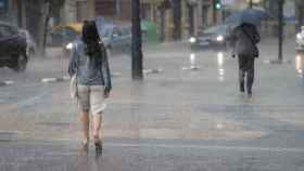 Dos personas pasean bajo la lliuvia este lunes en la Comunidad Valenciana, en imagen de archivo.