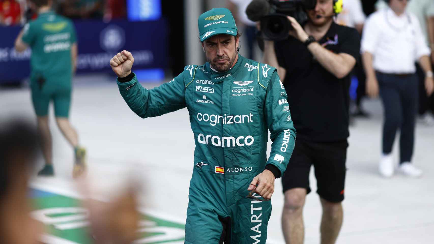 Fernando Alonso realiza un gesto ganador en el paddock.