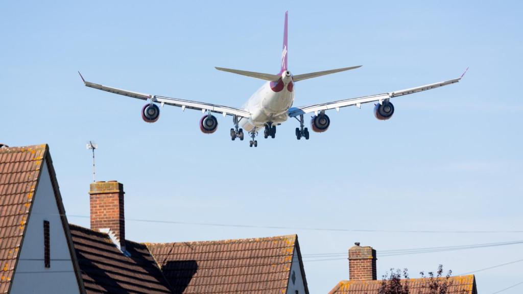 Un avión comercial volando cerca de un núcleo urbano