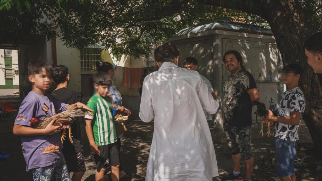 Macarena Olona con una familia gitana en las Tres Mil Viviendas de Sevilla, este jueves.