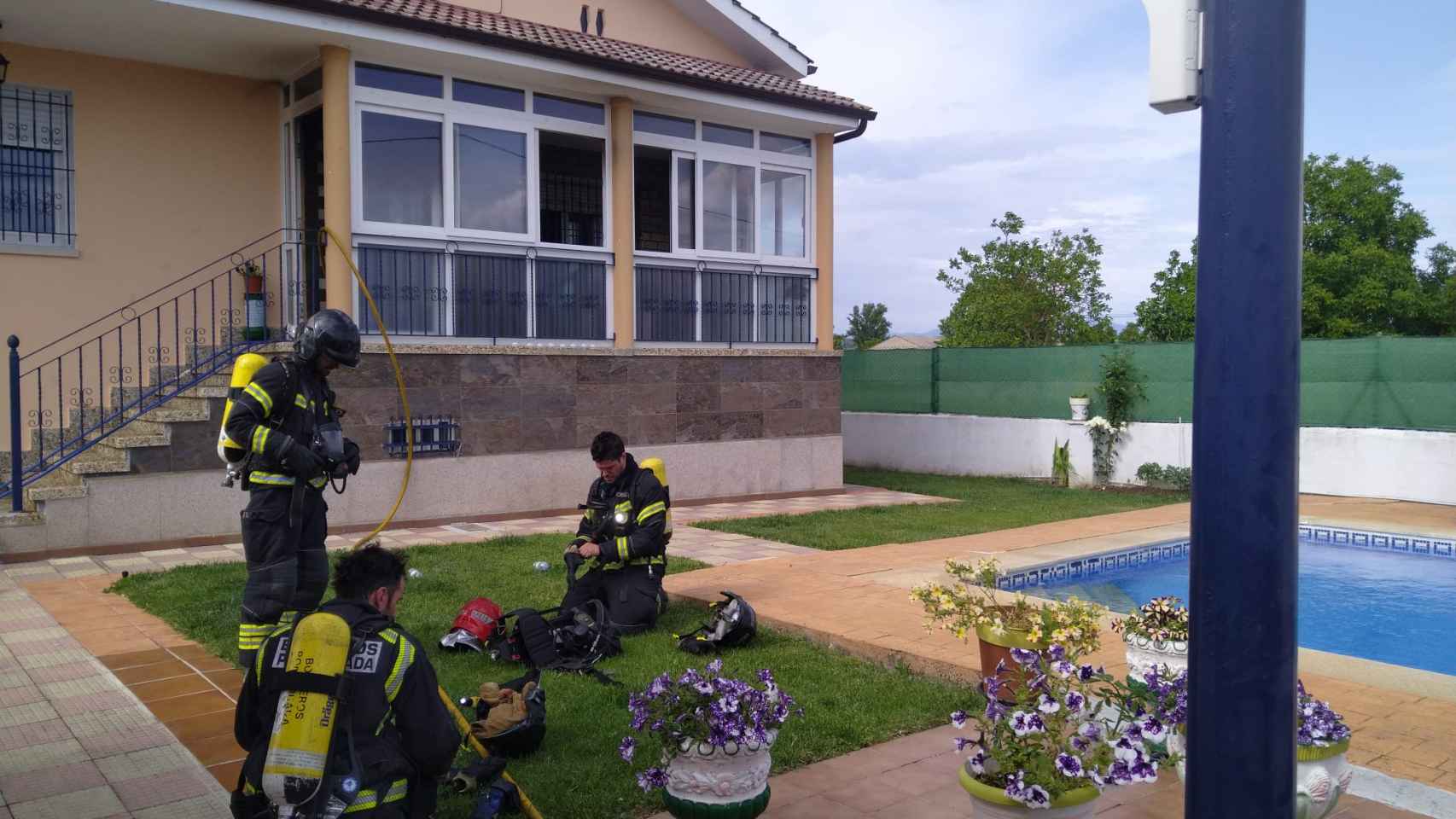 Los bomberos en el jardín de la vivienda