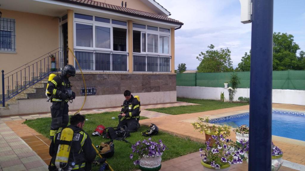 Los bomberos en el jardín de la vivienda