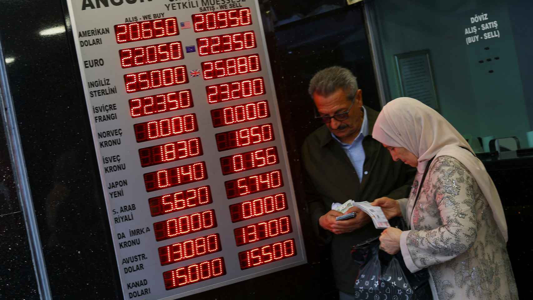 Varias personas visitan una oficina de cambio de divisas este lunes.
