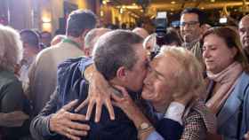 Emiliano García-Page abraza a una persona en la noche electoral