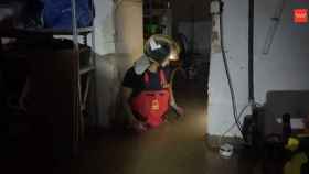 Un bombero interviene en un sótano inundado.
