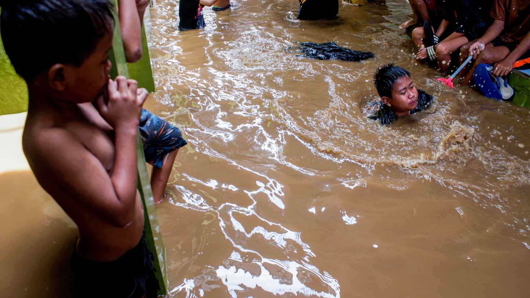 Niños indonesios juegan en un callejón inundado en Yakarta tras las inundaciones de octubre de 2020.