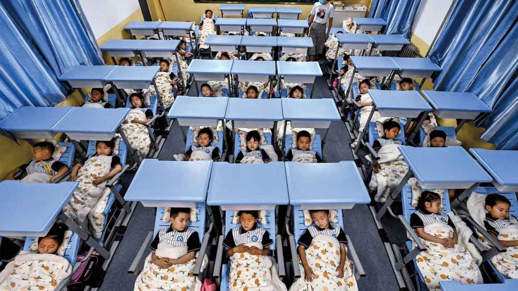 Niños durmiendo en un aula en China.