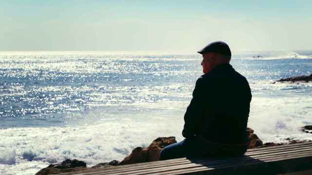 Imagen de archivo de una persona sola observando la inmensidad del océano.