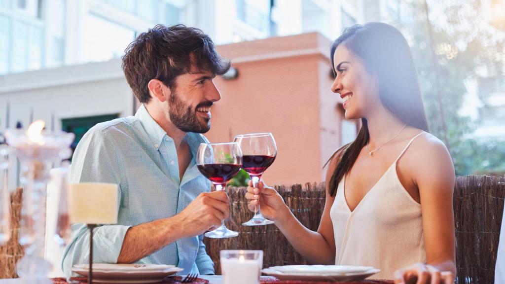 Una pareja brinda en la terraza de un restaurante.