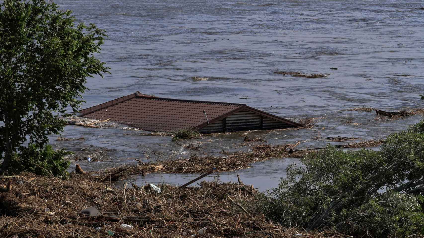 El techo de una casa en el río Dnipro, tras la ruptura de la presa de Nova Kajovka.