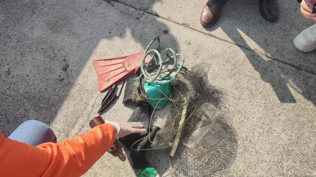 Rubén Rodríguez, responsable de proyectos de Vertidos Cero en Galicia, disecciona los objetos que recogió un pescador mientras buceaba para conseguir navajas.