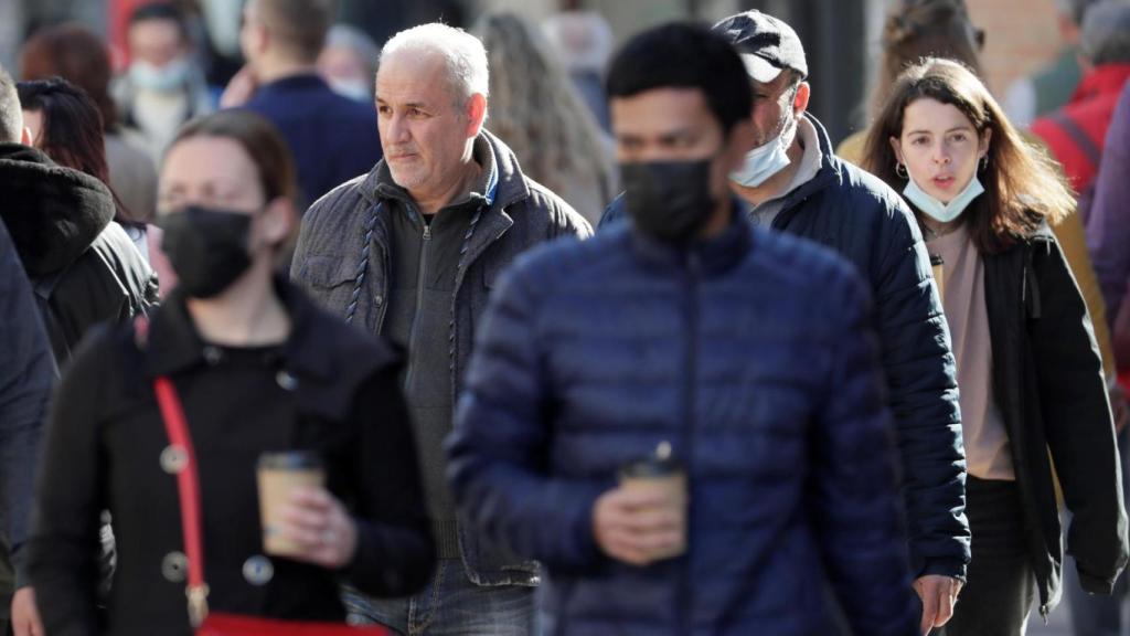 Personas con abrigo pasean por la calle