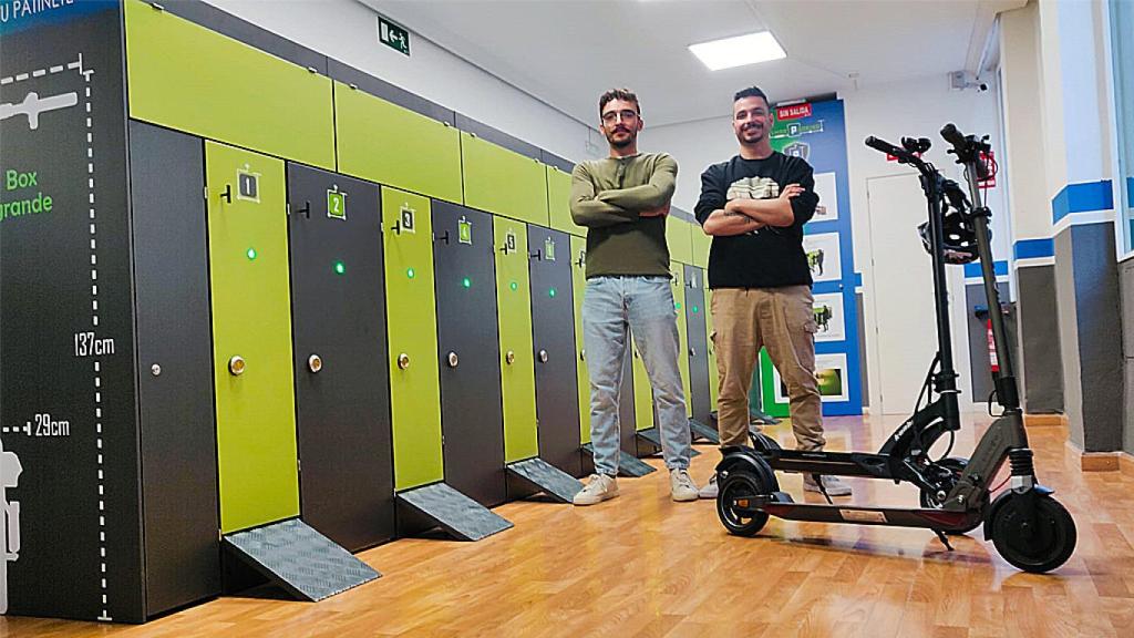 Álvaro y Roberto, los dos socios, en el aparcamiento para patinetes