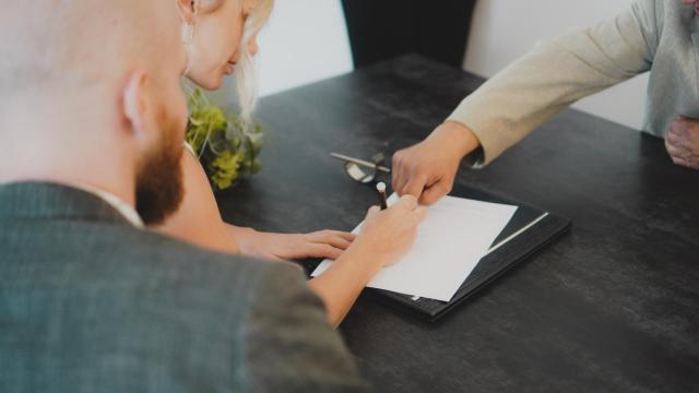 Una pareja firmando una herencia.