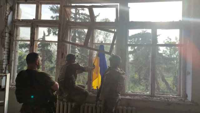 Soldados ucranianos colocan una bandera ucraniana en un edificio, durante una operación que pretende liberar la primera aldea en medio de la contraofensiva, Blahodatne (región de Donetsk).