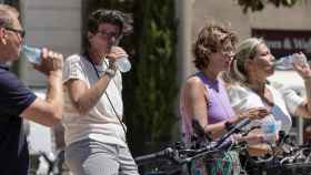Personas bebiendo agua por las altas temperaturas la semana pasada en Valencia.